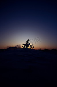 摩托车摄影照片_夜晚、天空和轮廓，人和摩托车在大自然中骑行，模拟背景下的极限运动。