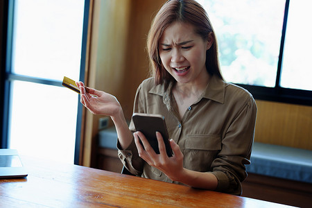 一名亚洲少女在使用手机网上购物时对信用卡被禁止表示不满的肖像