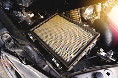 汽车发动机系统空气滤清器槽上的汽车空气滤清器，带阳光，汽车零部件概念