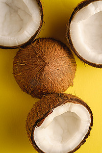 黄色平原背景的椰子果，抽象热带食品