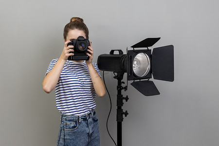 女人在照相馆拍照，使用 photocanera 和反射器。