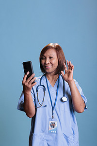 智能健康助理摄影照片_在线视频通话会议期间，欢快的微笑助理问候远程医生