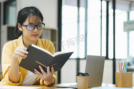 严肃的年轻亚洲学生正在读书准备考试。