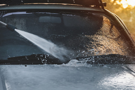 洗车服务中用高压水管清洗汽车挡风玻璃