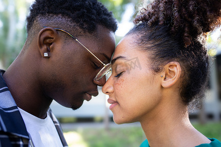 年轻的非裔美国情侣温柔地抚摸额头，分享浪漫、亲密、深情的时刻。