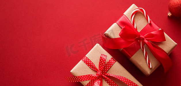 喜庆红色背景摄影照片_圣诞礼物、节礼日和传统节日礼物平躺，红色背景的经典圣诞礼盒，包装有节日装饰品和节日平躺装饰的礼物