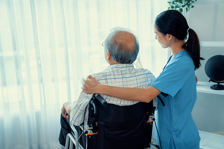 心满意足摄影照片_一名护理人员和她心满意足的老年患者一起在房间里的后视图。