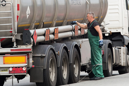 白俄罗斯戈梅利地区 — 2020年8月21日：身穿工作服的卡车司机抓住接地线或电线将机器接地。