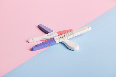 蓝色和粉色双色背景的妊娠测试。