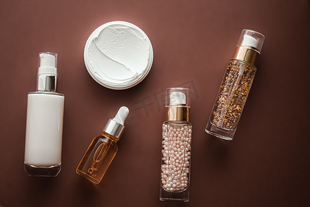 棕色背景中的护肤化妆品和抗衰老美容产品、豪华护肤瓶、油、血清和面霜