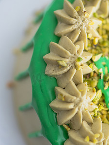 绿色开心果磨砂滴糖霜杯蛋糕，顶部撒有糖粉