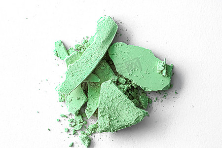 绿色眼影粉作为化妆调色板特写，隔离在白色背景、破碎的化妆品和美容质感中