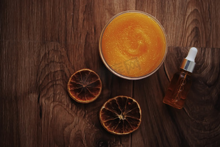 质朴木质背景的柑橘和蜂蜜橙色身体磨砂罐、美容化妆品和护肤品