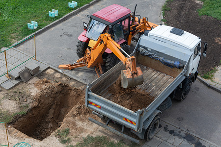 创意2018摄影照片_白俄罗斯，明斯克-2018年8月15日：带铲斗挖掘机负载的拖拉机