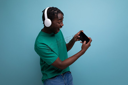 带无线耳机和功能强大的智能手机的非洲玩家