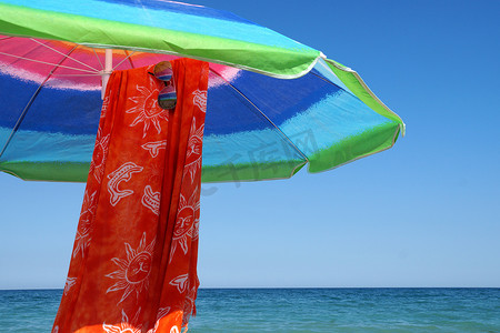 海平线摄影照片_沙滩伞、帕雷奥和太阳镜，映衬着海平线和晴朗的天空，复制空间