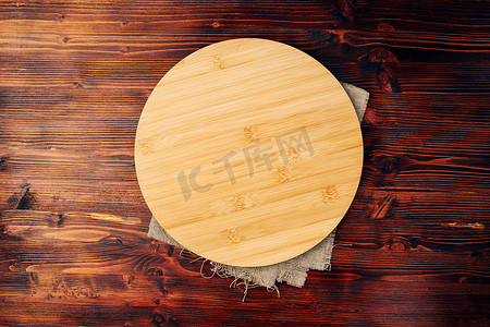 木质空托盘摄影照片_木质背景上的空圆形厨房板，空的复印空间