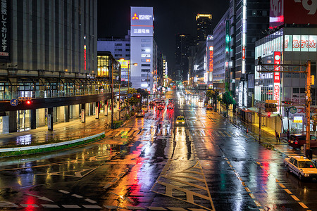 日本大阪 — 2023年4月12日：雨夜大阪市中心潮湿的街道上反射着灯光