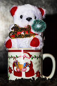 在黑色隔离的圣诞杯中装饰泰迪熊。