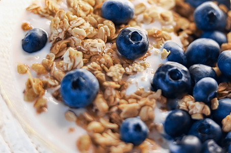 早餐创意和美味的食物，早餐谷物搭配无乳糖酸奶和碗里的新鲜有机蓝莓，美味健康的食谱