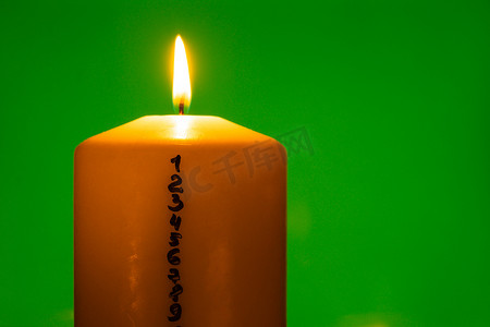 与出现日历的蜡烛在绿色色度键背景传统燃烧的圣诞蜡蜡烛与倒计时圣诞节的数字。