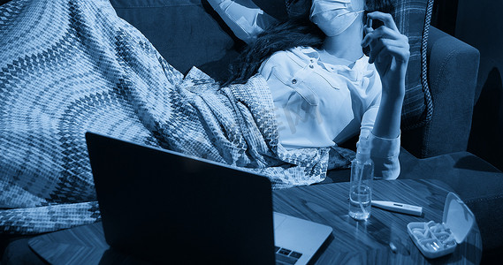 沙发上的年轻女子盖着毯子，冻得流鼻涕，发烧，被抓，生病的女孩有流感症状、流感或病毒概念