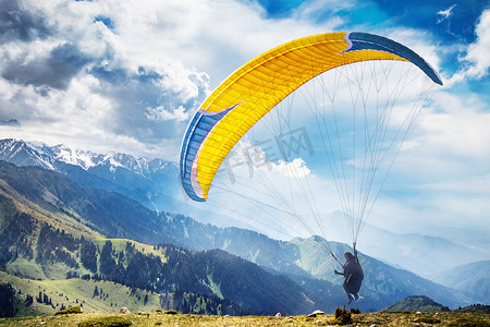 商务风宣传单摄影照片_令人惊叹的山景与飞行滑翔伞