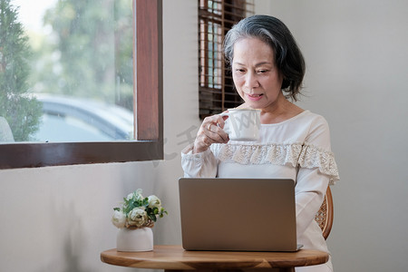 聪明的亚洲成熟中年女商人首席执行官老板领导老师使用笔记本电脑、电子学习、在家办公室远程在线工作
