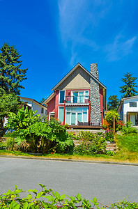 社区蓝天摄影照片_美丽的郊区房子，有景观露台和蓝天背景