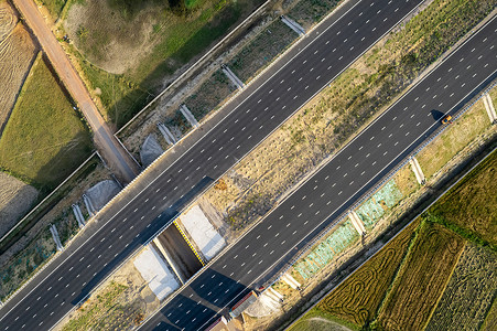 空中无人机拍摄的新德里孟买斋浦尔高速高架公路沿线直下拍摄，显示六车道道路，有绿色田野和矩形农场