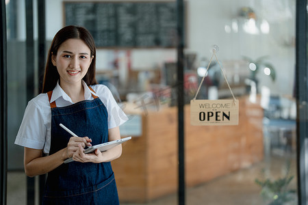创业成功的小企业主中小企业美容女孩在咖啡店餐厅里拿着平板电脑站着，亚洲棕褐色女咖啡师咖啡馆老板，企业家卖家的商业理念