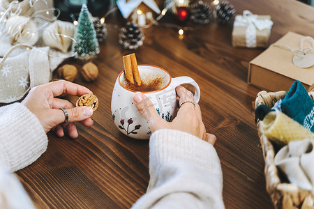 圣诞杯咖啡加肉桂在女人手中。