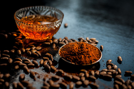 黑色木质表面上的抗衰老咖啡面膜，由一些咖啡豆和蜂蜜组成。
