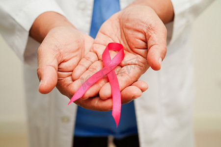 乳腺癌治疗摄影照片_带粉红丝带的亚洲女医生，十月世界乳腺癌日。