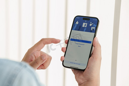 手机和app摄影照片_泰国清迈 - 2023 年 2 月 12 日：女手使用 iPhone 14 和 Metaverse 的 facebook 应用程序。