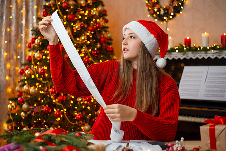 圣诞节购物后，一个女孩手里拿着很长的账单