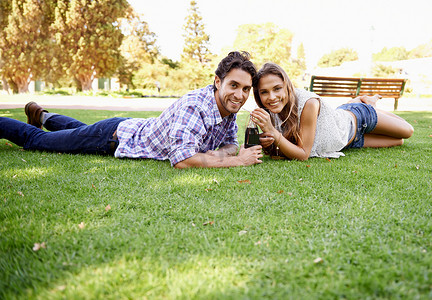 情人节情侣表摄影照片_幸福的情侣、公园和情人节约会肖像，在草地上喝一杯，以表达爱、联系和共度时光。