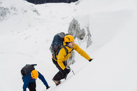 穿着黄色夹克的登山者为那些咆哮的人引路，攀登雪山
