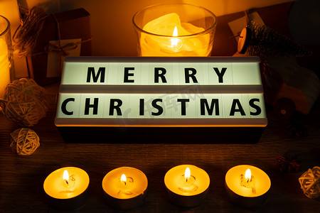 四根蜡烛，带有出现日历灯箱，上面有文字“圣诞快乐”传统燃烧的圣诞蜡蜡烛，上面有圣诞节倒计时的数字。