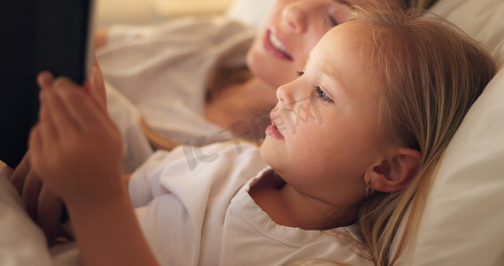 平板电脑、母亲和孩子在床上上网、流媒体电影或晚上在网上读书。