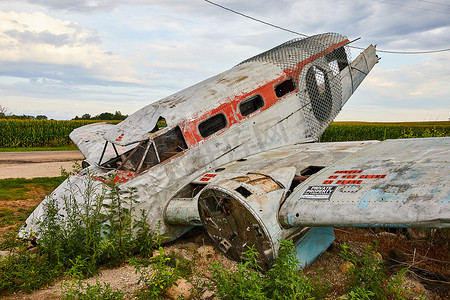 废弃被毁飞机在田野休息的侧视图