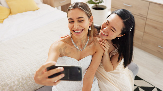 时尚发布摄影照片_新娘、伴娘和带着电话、婚礼和戒指的自拍，微笑着发布在社交媒体上。