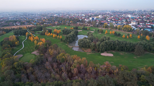 秋天，人们在绿色的田野上打高尔夫球