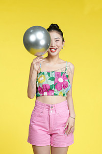 女士生日摄影照片_迷人的女士手持气球装饰生日派对隔离黄色背景