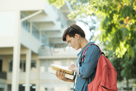 学生站在户外拿着书本。