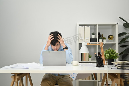 沮丧的商人抱头头痛，因过度劳累或工作压力而疲惫不堪