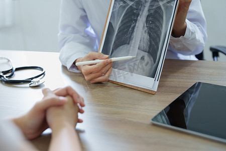 解释摄影照片_一位亚洲女医生指着病人的X光片解释病人的治疗过程
