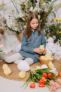 复活节照片摄影照片_两个女孩在一个美丽的复活节拍照区，里面有鲜花、鸡蛋、鸡和复活节兔子。