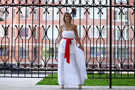 丝质裙子摄影照片_夏天街头穿白裙子的女士