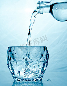 菜单黑金摄影照片_新鲜干净的水从瓶子里倒入玻璃杯中。